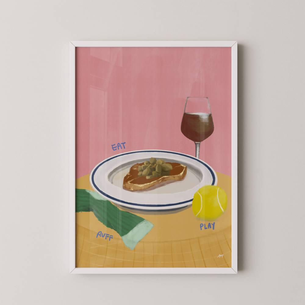Framed artwork with a pink background, plate of food, glass of wine, tennis ball, and text on a white wall.