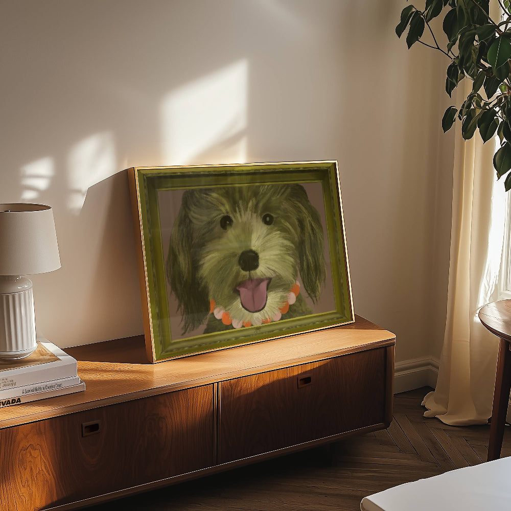 Framed portrait of a goldendoodle on a wooden cabinet with a lamp and plant in the background